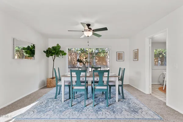 a dining room with furniture potted plants and wooden floor