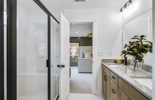 a bathroom with a granite countertop sink a mirror and a shower