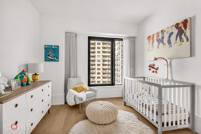 a bedroom with baby crib and a window