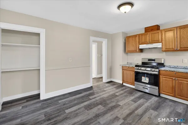 a kitchen with granite countertop a stove and a refrigerator