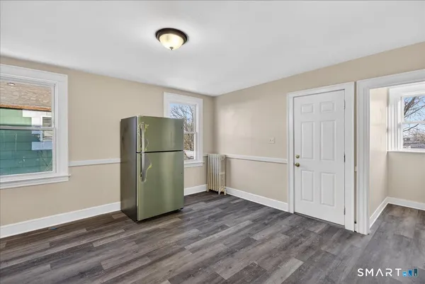a view of empty room with wooden floor and window