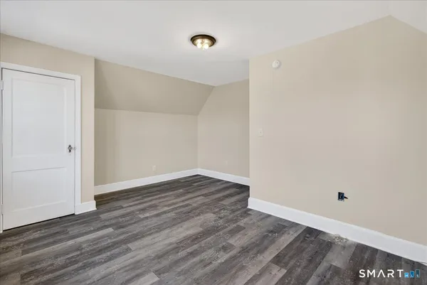a view of an empty room with wooden floor