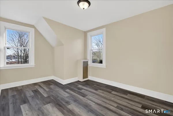 a view of empty room with wooden floor