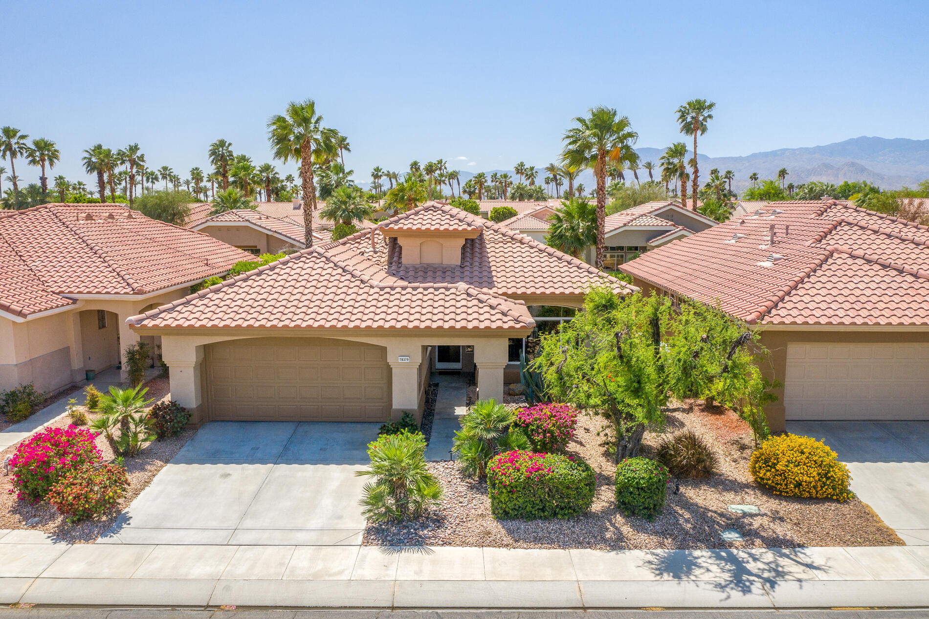 78379 Moongold Road Palm Desert, CA 92211 - Photo 1 of 40 a front view of a house with a garden and potted plants