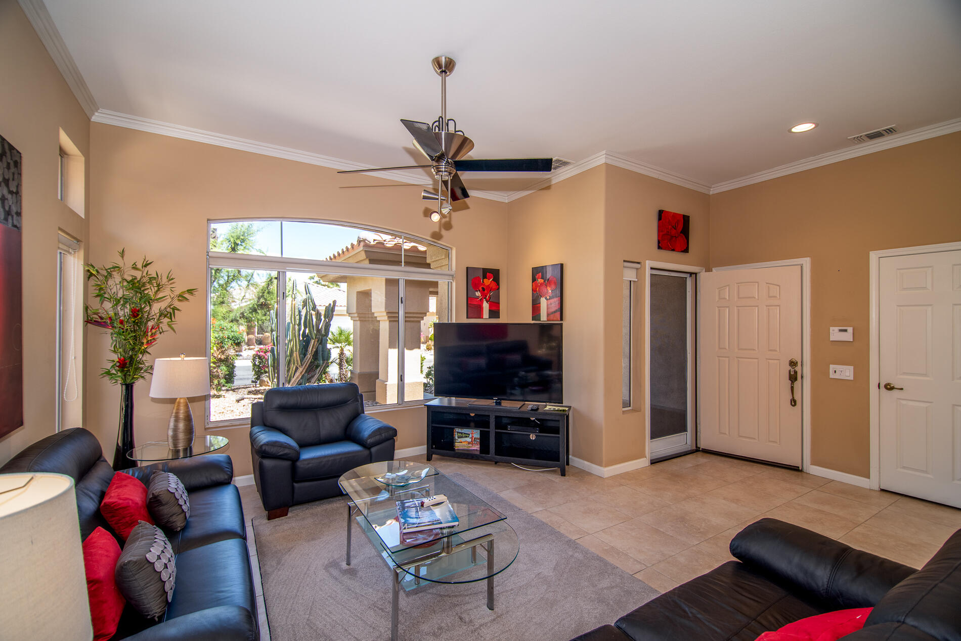 78379 Moongold Road Palm Desert, CA 92211 - Photo 12 of 40 a living room with furniture a flat screen tv and a chandelier