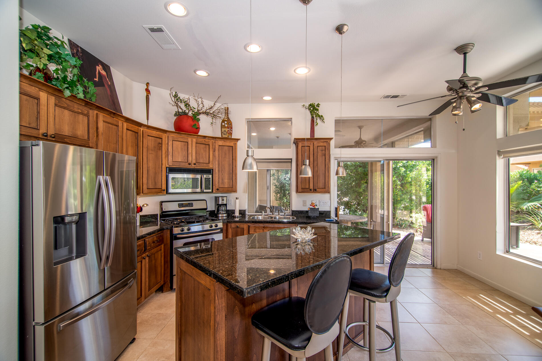 78379 Moongold Road Palm Desert, CA 92211 - Photo 19 of 40 a kitchen with stainless steel appliances granite countertop a sink refrigerator and microwave