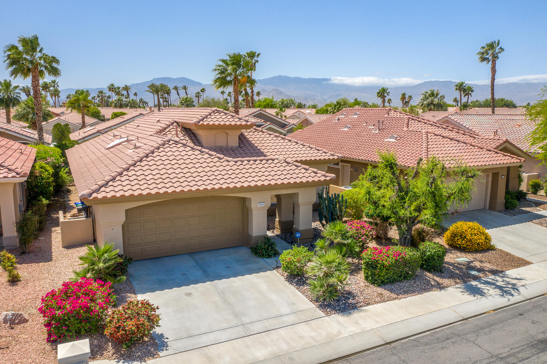 78379 Moongold Road Palm Desert, CA 92211 - Photo 30 of 40 a front view of a house with a yard and a garden