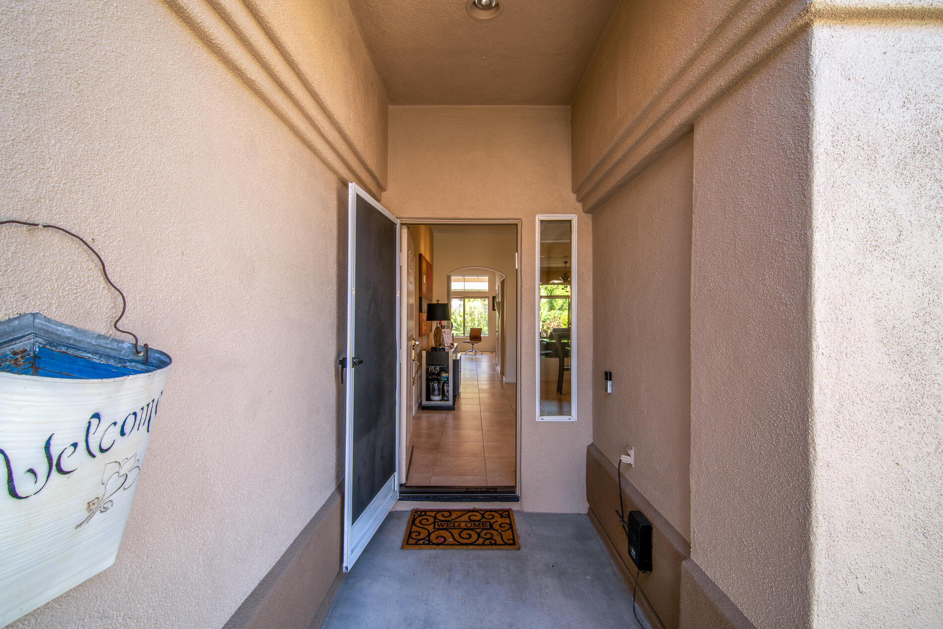 78379 Moongold Road Palm Desert, CA 92211 - Photo 4 of 40 a view of a hallway with wooden floor and a living room