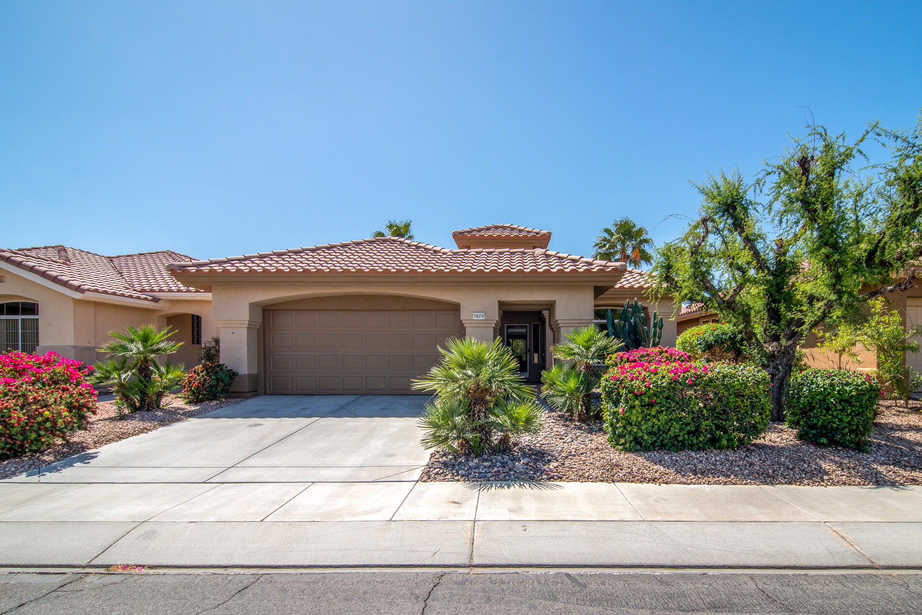 78379 Moongold Road Palm Desert, CA 92211 - Photo 5 of 40 a front view of a house with a garden