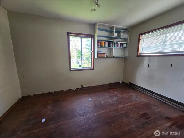 an empty room with windows and cabinet
