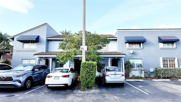a front view of a house with a cars parked