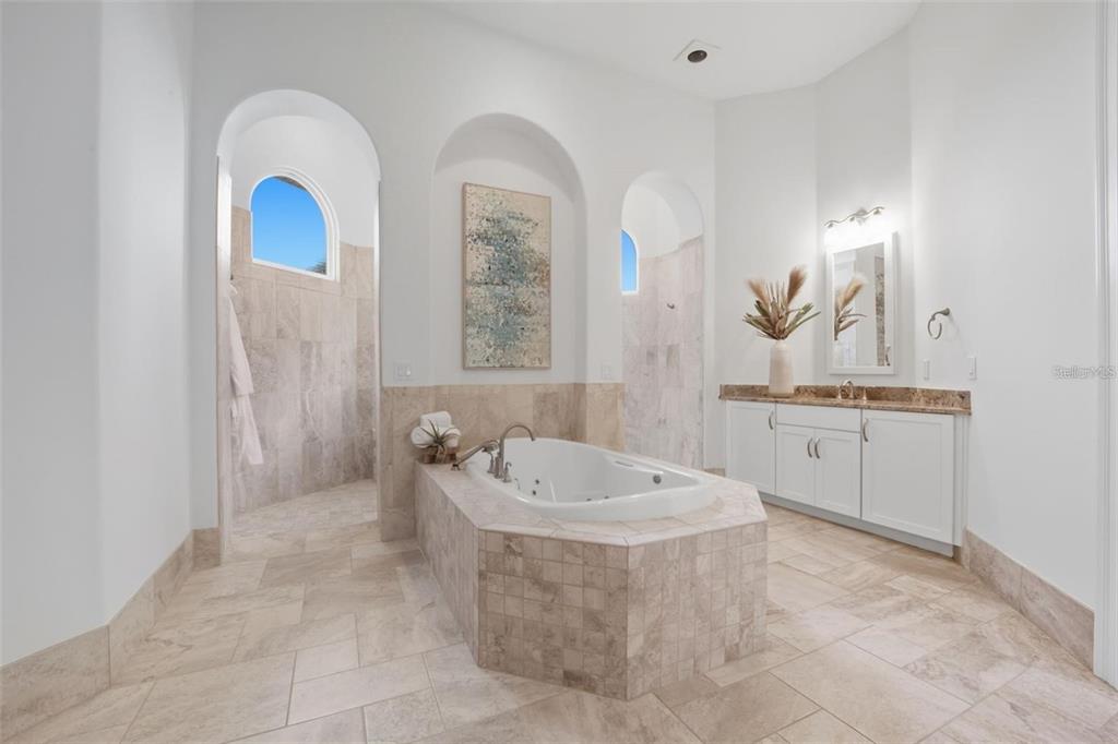 3215 Gulf City Road Ruskin, FL 33570 - Photo 26 of 99 a spacious bathroom with a double vanity sink a mirror and a bathtub