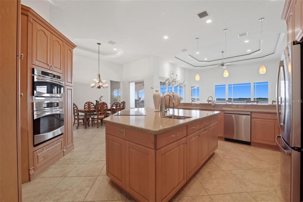 3215 Gulf City Road Ruskin, FL 33570 - Photo 42 of 99 a kitchen with stainless steel appliances granite countertop a table chairs sink and cabinets