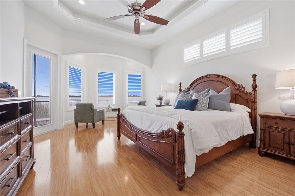 3215 Gulf City Road Ruskin, FL 33570 - Photo 49 of 99 a bedroom with a large bed a chandelier and windows