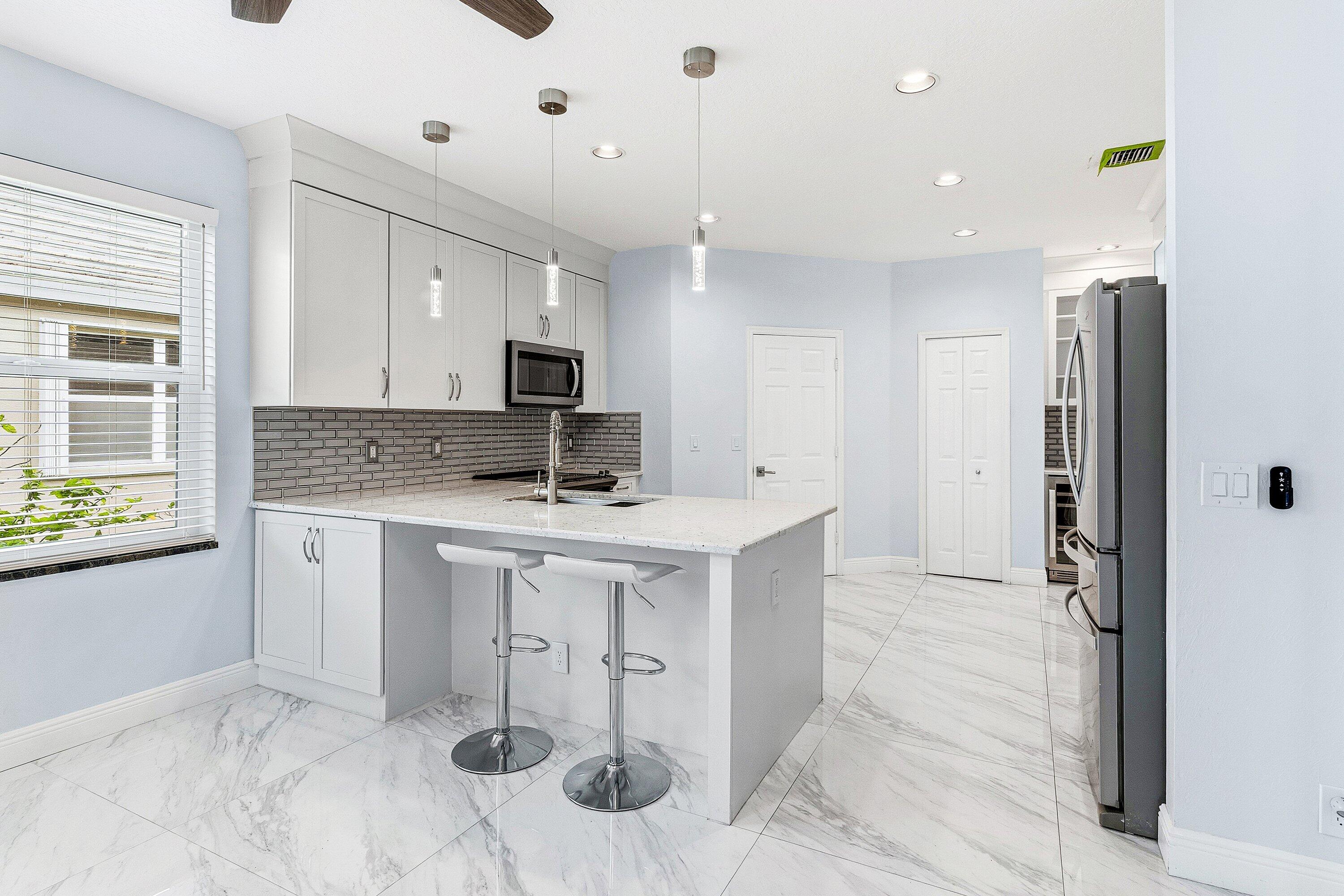 12403 Cascades Pointe Drive Boca Raton, FL 33428 - Photo 13 of 65 a kitchen with a refrigerator and a sink