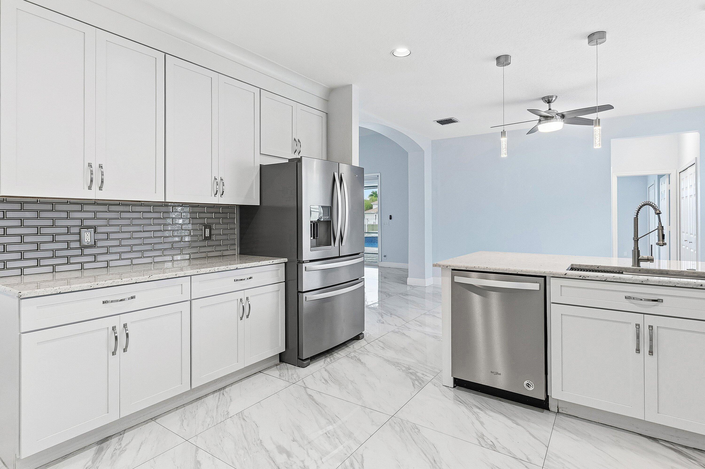 12403 Cascades Pointe Drive Boca Raton, FL 33428 - Photo 15 of 65 a kitchen with granite countertop white cabinets white stainless steel appliances with a sink and dishwasher