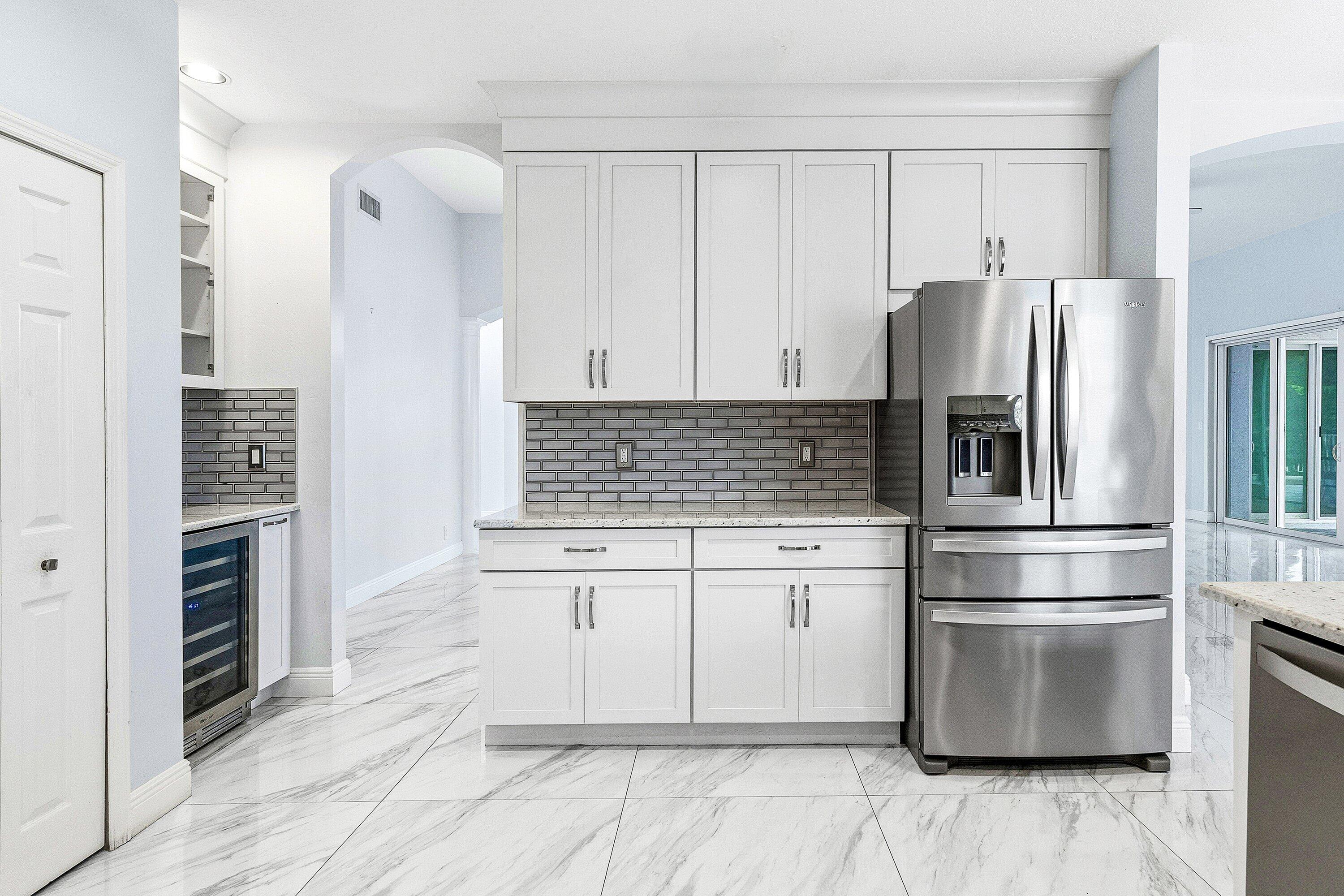 12403 Cascades Pointe Drive Boca Raton, FL 33428 - Photo 16 of 65 a kitchen with granite countertop a refrigerator and a stove top oven
