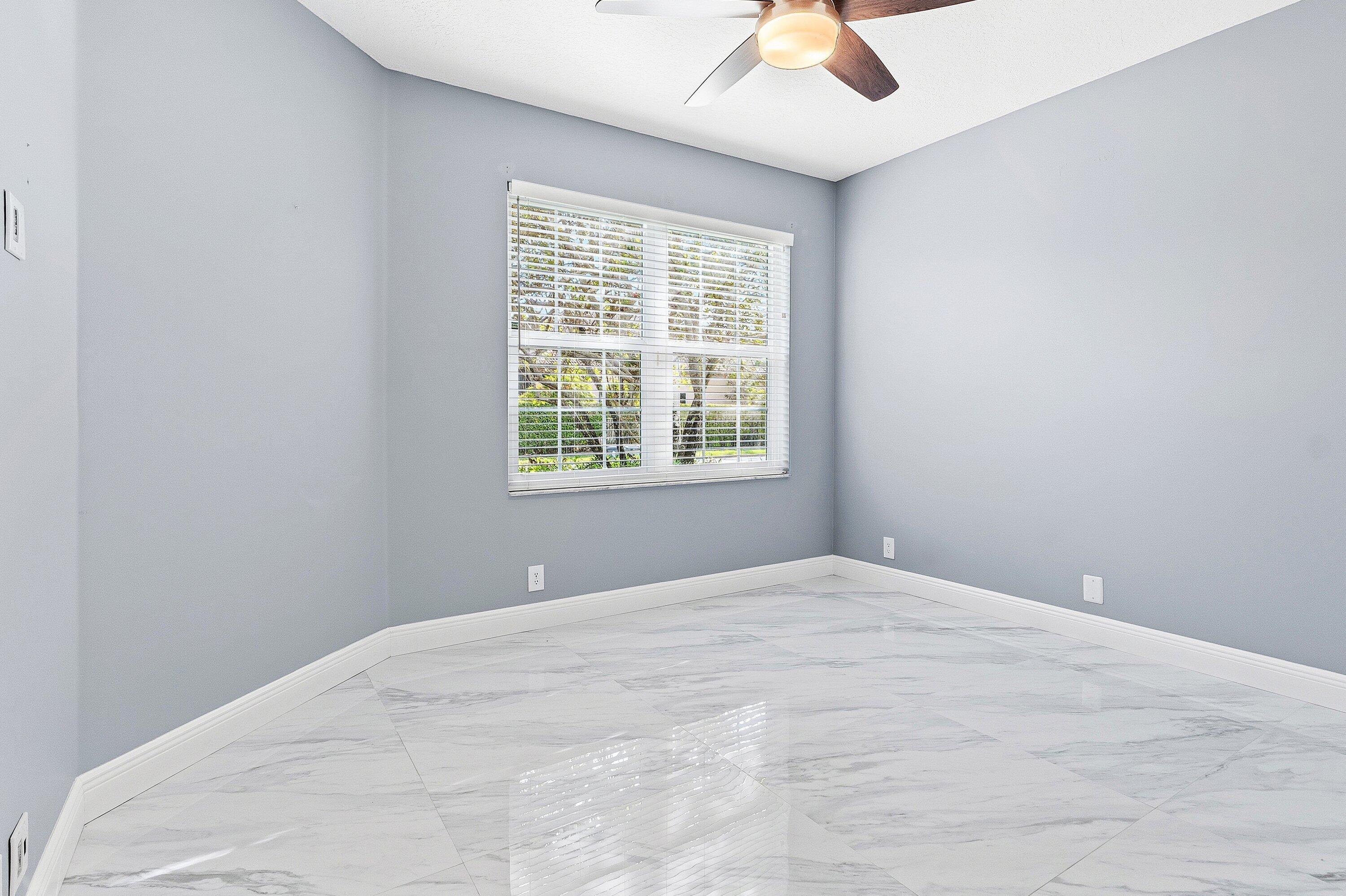 12403 Cascades Pointe Drive Boca Raton, FL 33428 - Photo 31 of 65 a view of a bedroom with a window and a ceiling fan
