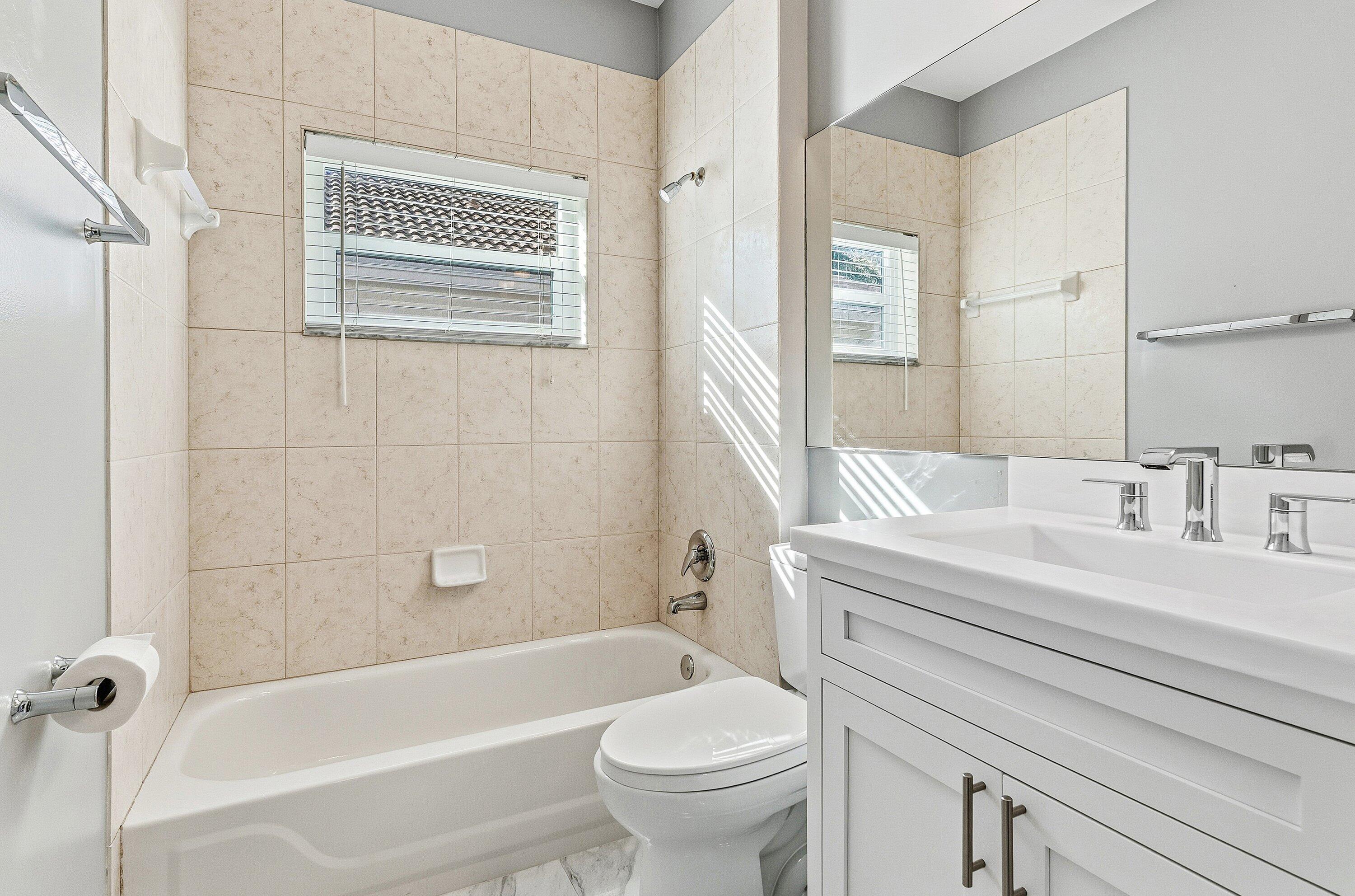 12403 Cascades Pointe Drive Boca Raton, FL 33428 - Photo 32 of 65 a bathroom with a sink a toilet and a bathtub