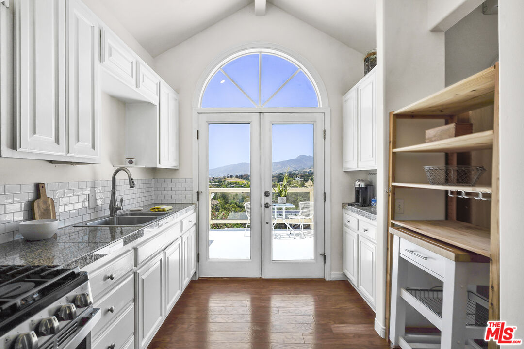 29355 Heathercliff Road, Unit GUESTHOUSE Malibu, CA 90265 - Photo 4 of 26 a kitchen with stainless steel appliances granite countertop a sink and a stove top oven