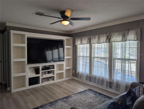 a kitchen with stainless steel appliances granite countertop a stove a sink a microwave a refrigerator and white cabinets