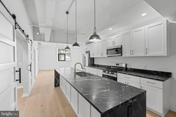 a kitchen with stainless steel appliances granite countertop a sink a stove and a refrigerator