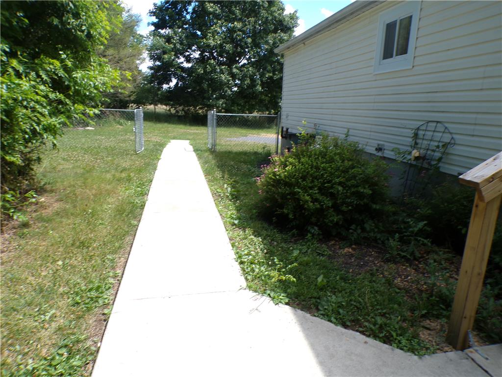 7877 Gun Club Road New Tripoli, PA 18066 - Photo 16 of 19 A side pathway leads to a fully fenced yard, offering a private outdoor retreat.