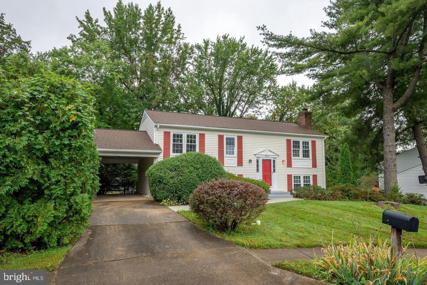 a front view of a house with a yard and trees