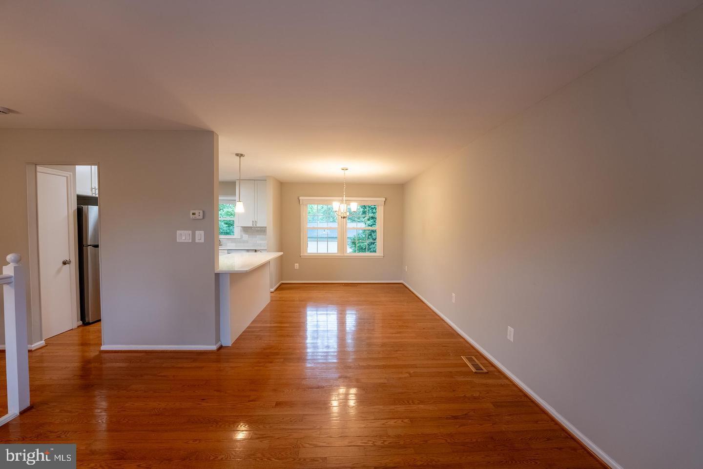 5629 Signal Point Court Burke, VA 22015 - Photo 12 of 48 a view of a hallway with wooden floor and a kitchen