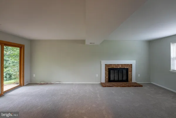 an empty room with a fireplace and window