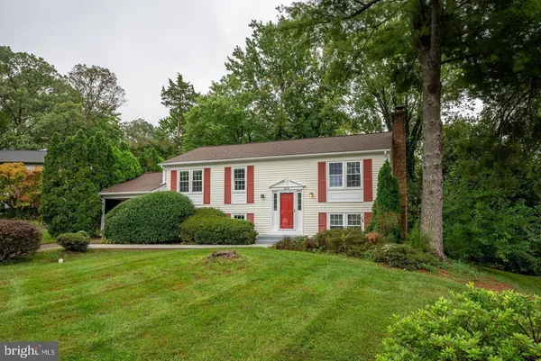 a front view of a house with a yard and trees