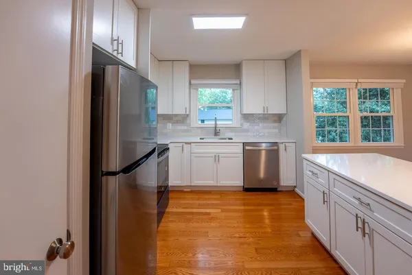 a kitchen with stainless steel appliances a sink stove and refrigerator