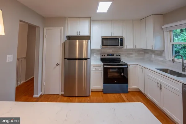 a kitchen with a refrigerator and a stove top oven