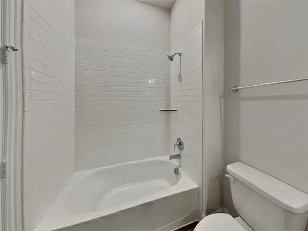 a bath room with a toilet and a bath tub