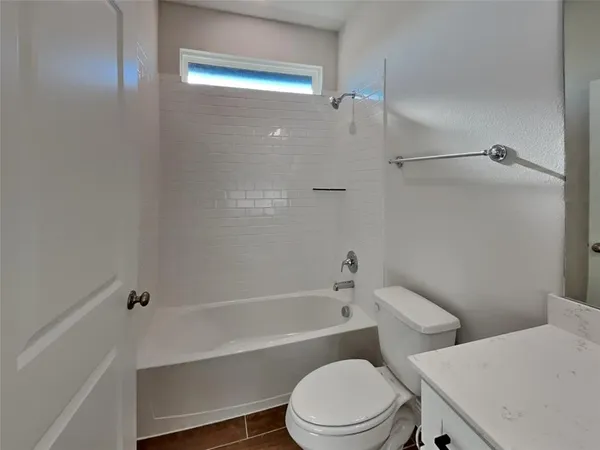 a white toilet and tub sitting next to a bathroom sink