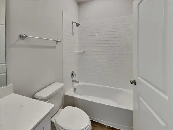 a white toilet and tub sitting next to a bathroom sink