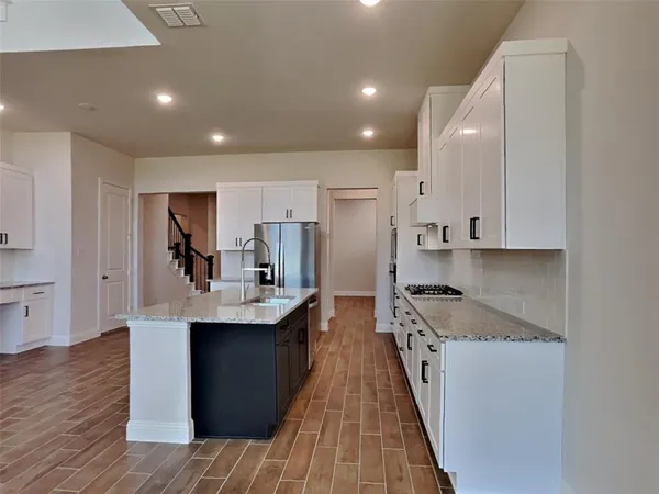 a kitchen with stainless steel appliances granite countertop a sink stove and refrigerator