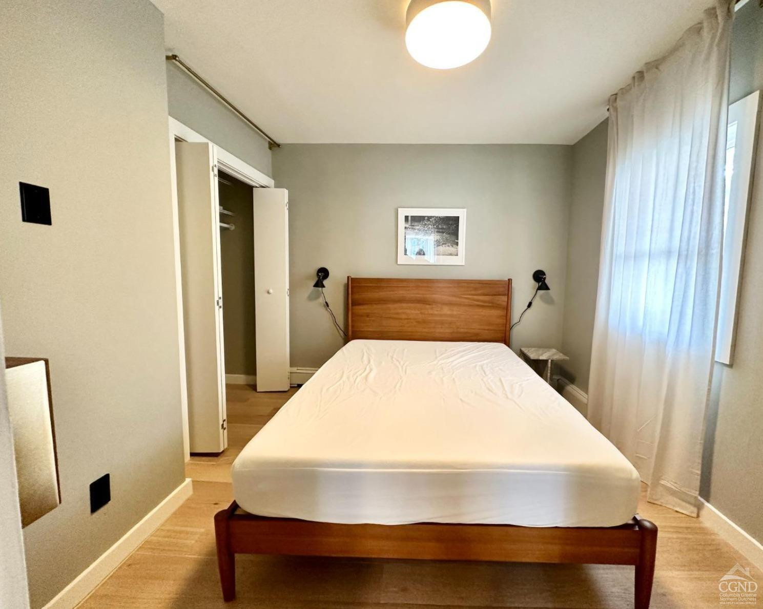 261 Main Street, Unit 6 Catskill, NY 12414 - Photo 4 of 10 a bedroom with a bed and a window