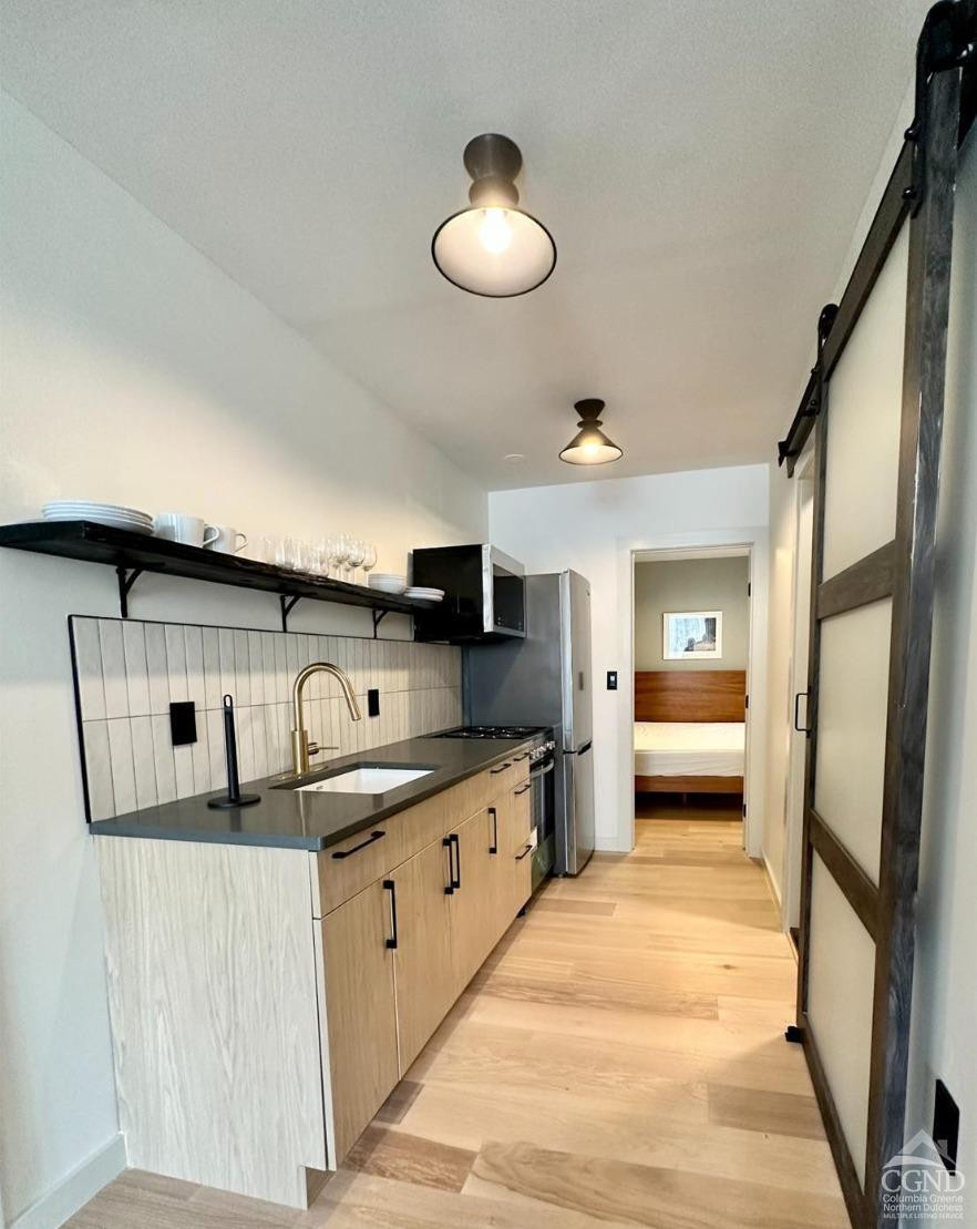 261 Main Street, Unit 6 Catskill, NY 12414 - Photo 6 of 10 a kitchen with stainless steel appliances granite countertop a sink and cabinets