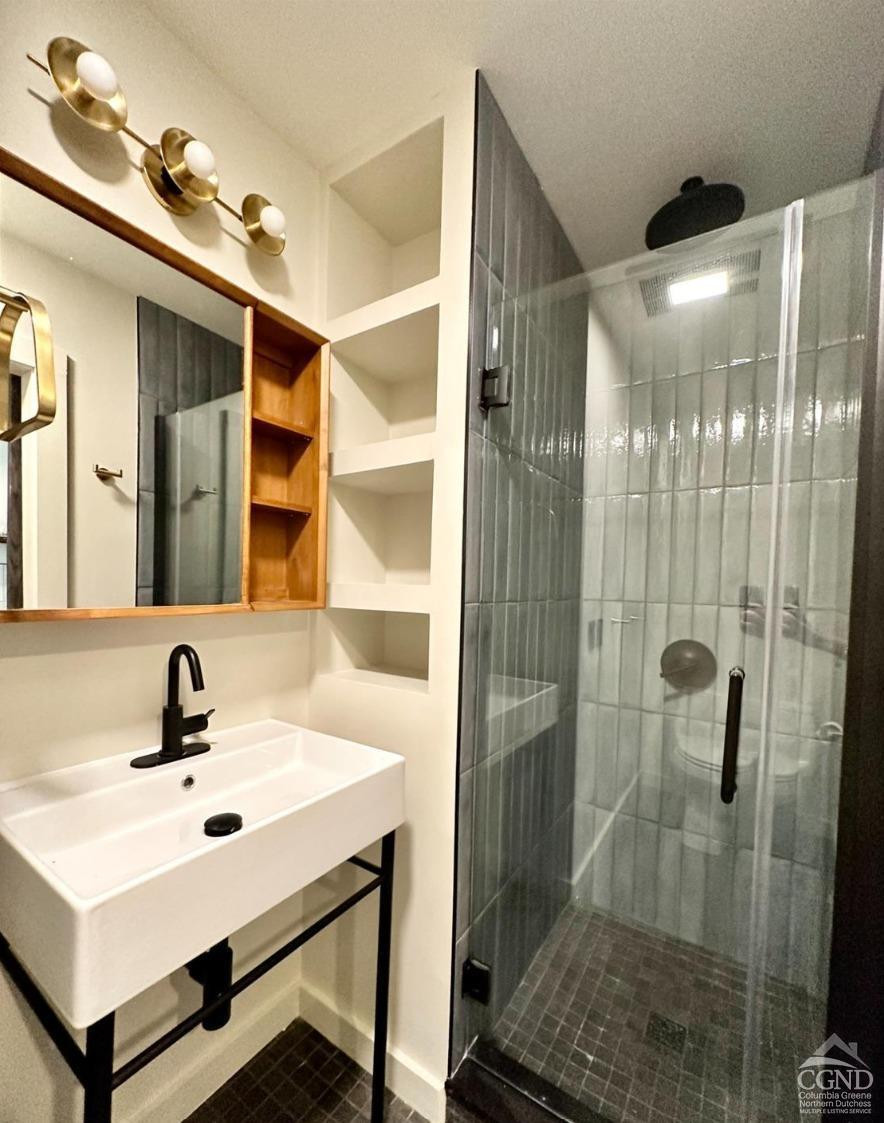 261 Main Street, Unit 6 Catskill, NY 12414 - Photo 7 of 10 a bathroom with a sink mirror and shower