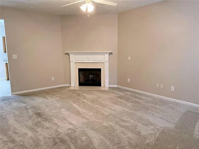 an empty room with a fireplace and fan