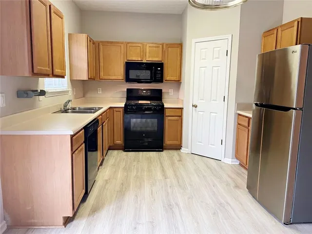 a kitchen with a refrigerator a stove top oven a sink and dishwasher