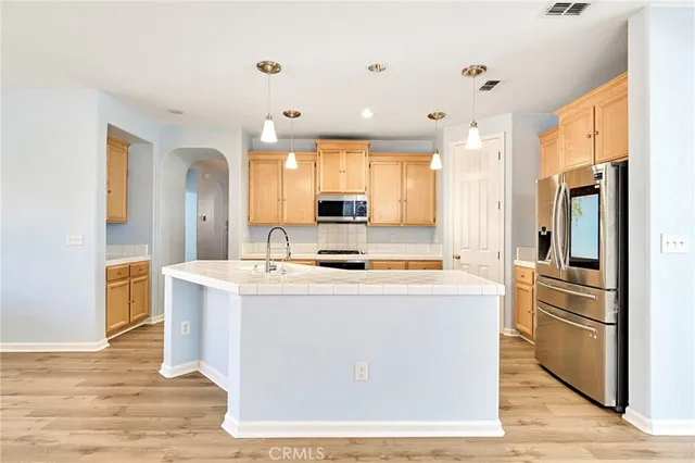 a kitchen with kitchen island a sink stove and refrigerator