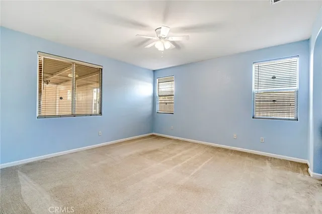 a view of an empty room with a ceiling fan