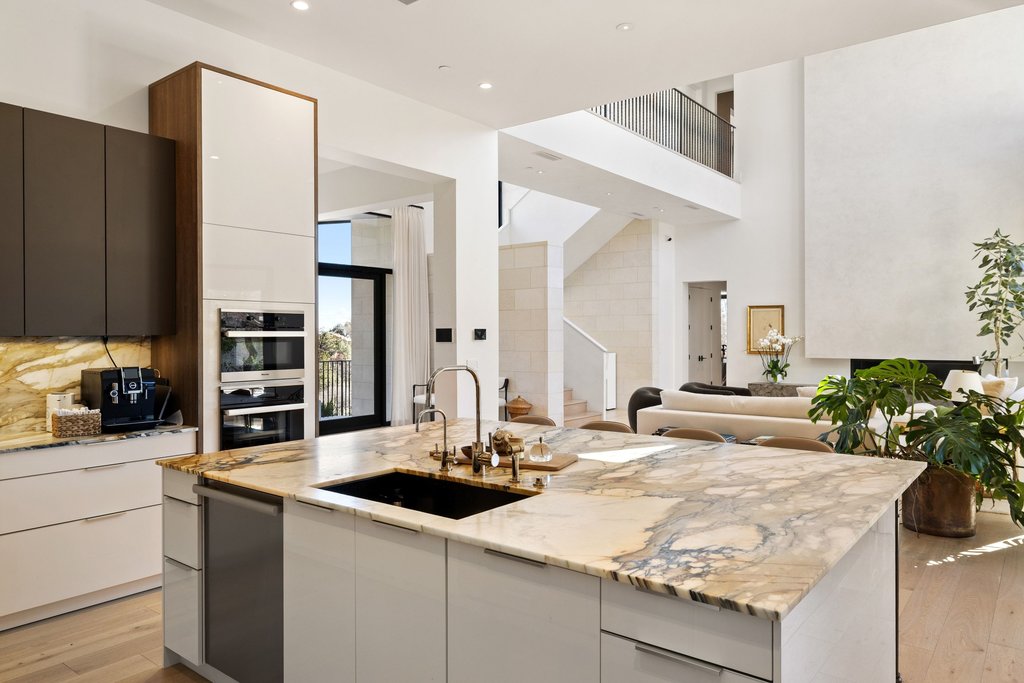 5 Inwood Cove Austin, TX 78746 - Photo 39 of 39 Two tone kitchen with light wood-type flooring, modern cabinets, light stone countertops, open floor plan, and a high ceiling