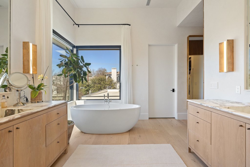 5 Inwood Cove Austin, TX 78746 - Photo 28 of 39 Full bathroom featuring two vanities, a freestanding bath, and light wood-style flooring