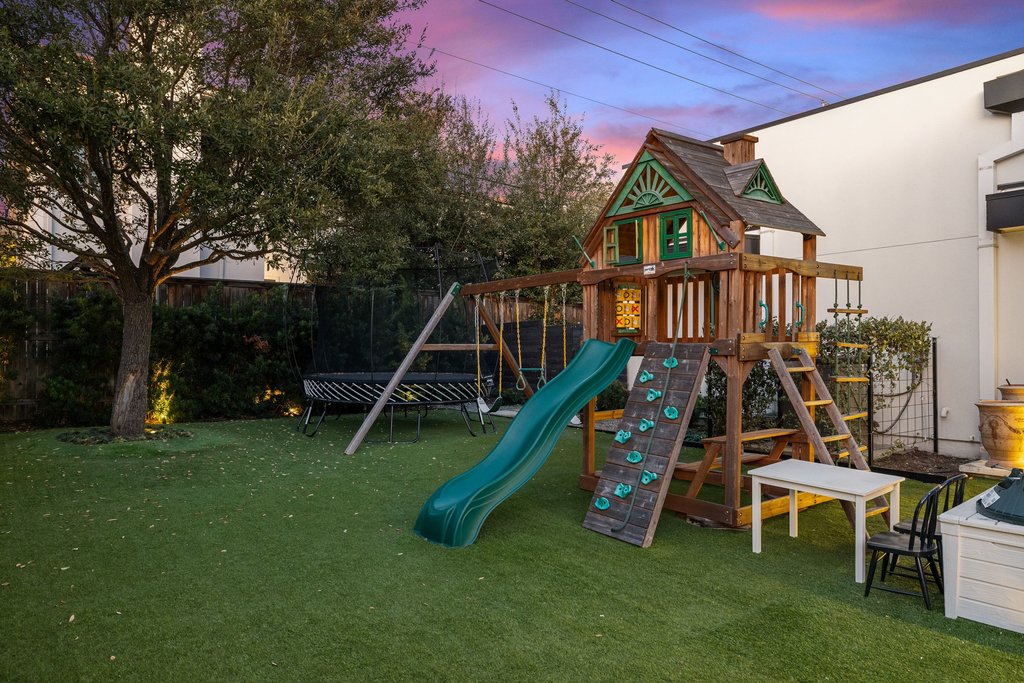 5 Inwood Cove Austin, TX 78746 - Photo 36 of 39 Playground at dusk featuring a fenced backyard, a trampoline, and a playground