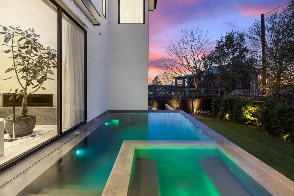 5 Inwood Cove Austin, TX 78746 - Photo 5 of 39 Pool at dusk featuring a pool with connected hot tub and a patio