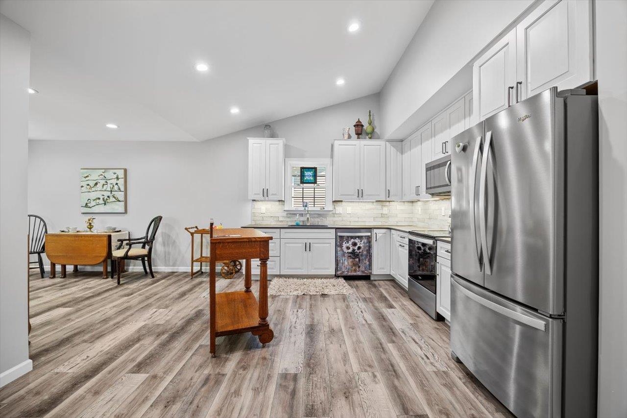 7 Oak View Drive Staunton, VA 24401 - Photo 6 of 53 a kitchen with stainless steel appliances a refrigerator a stove a sink dishwasher and a dining table with wooden floor