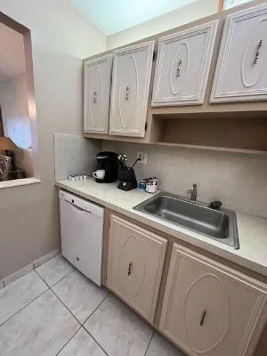 a kitchen with granite countertop white cabinets and sink